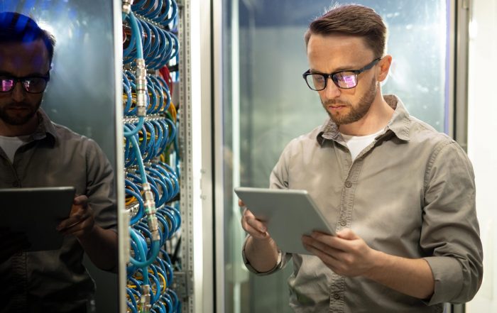 engineer using tablet in server room