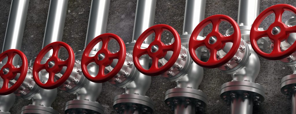 indsutrial pipelines and valves with red wheels on