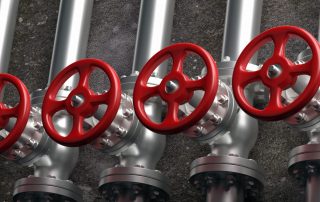 indsutrial pipelines and valves with red wheels on