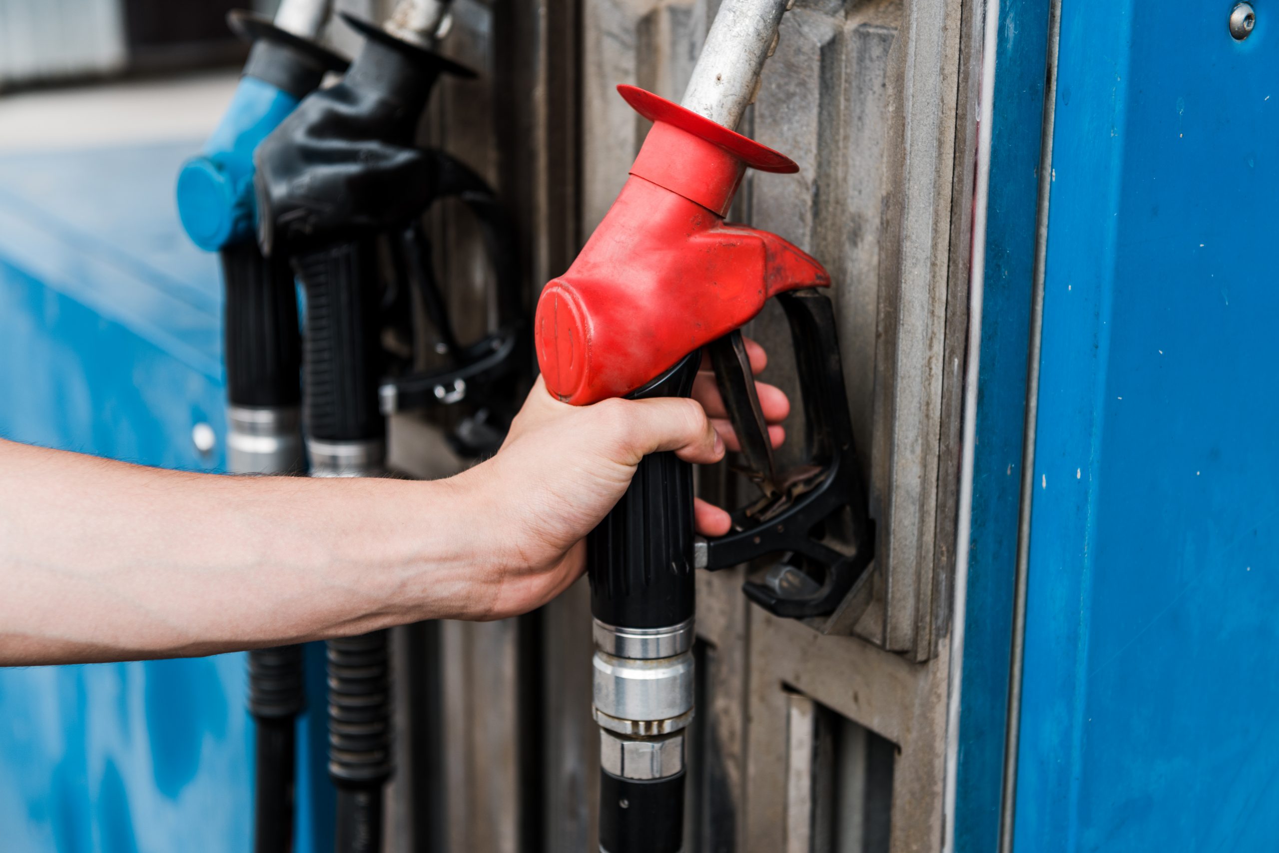 mand holding a red gas pump