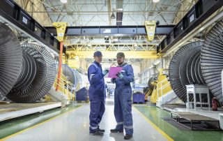 Engineers in discussion in turbine maintenance factory