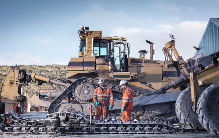 mining workers maintaining machine