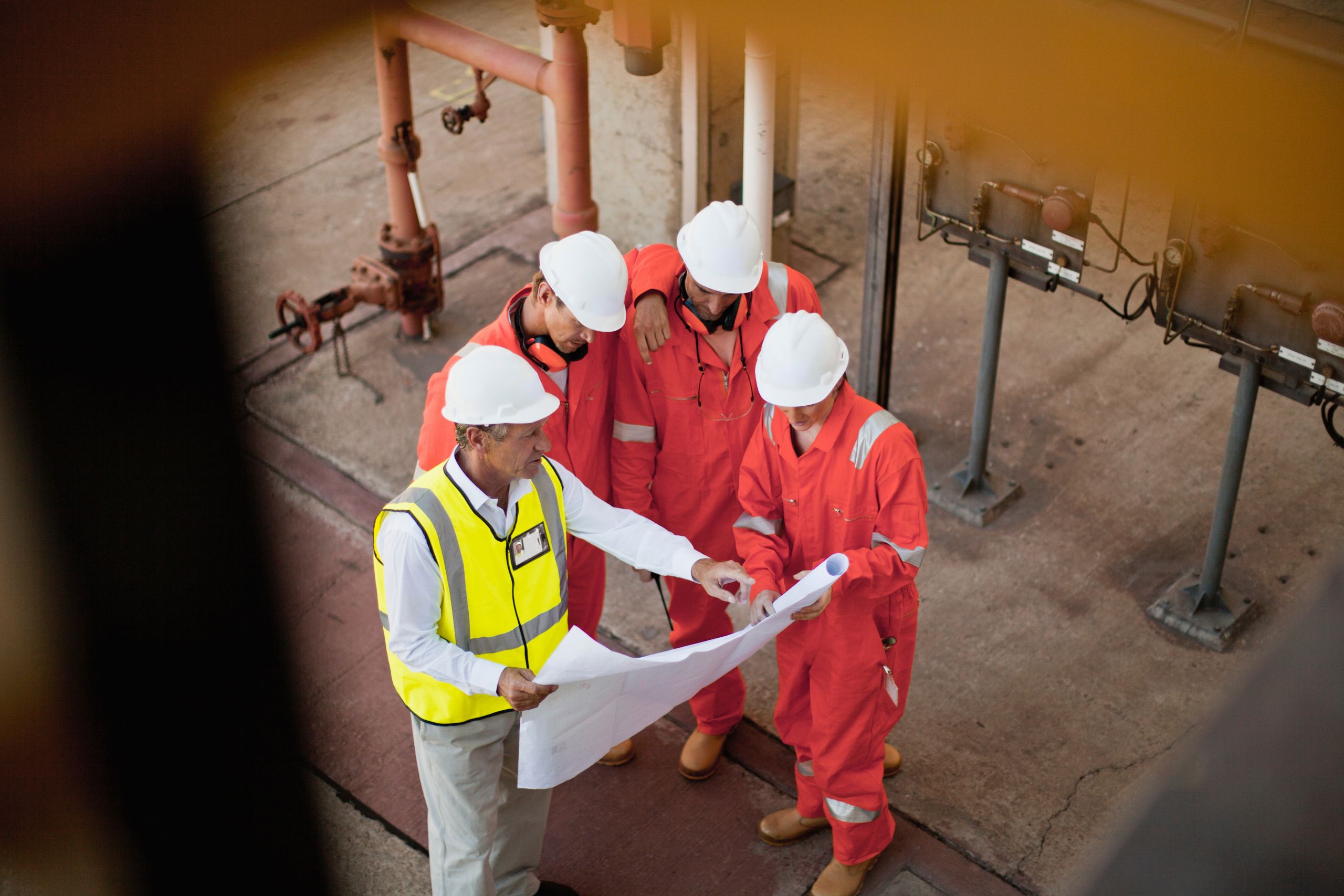 workers-with-blueprints-at-oil-refinery planning system integration