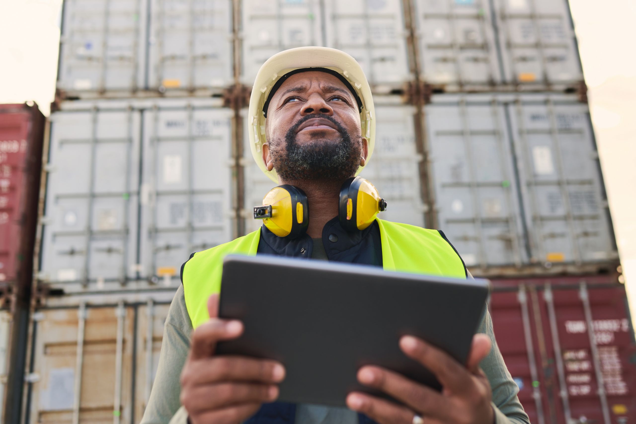 Logistics, tablet and black man doing container inspection at an industrial cargo, shipping and fre.