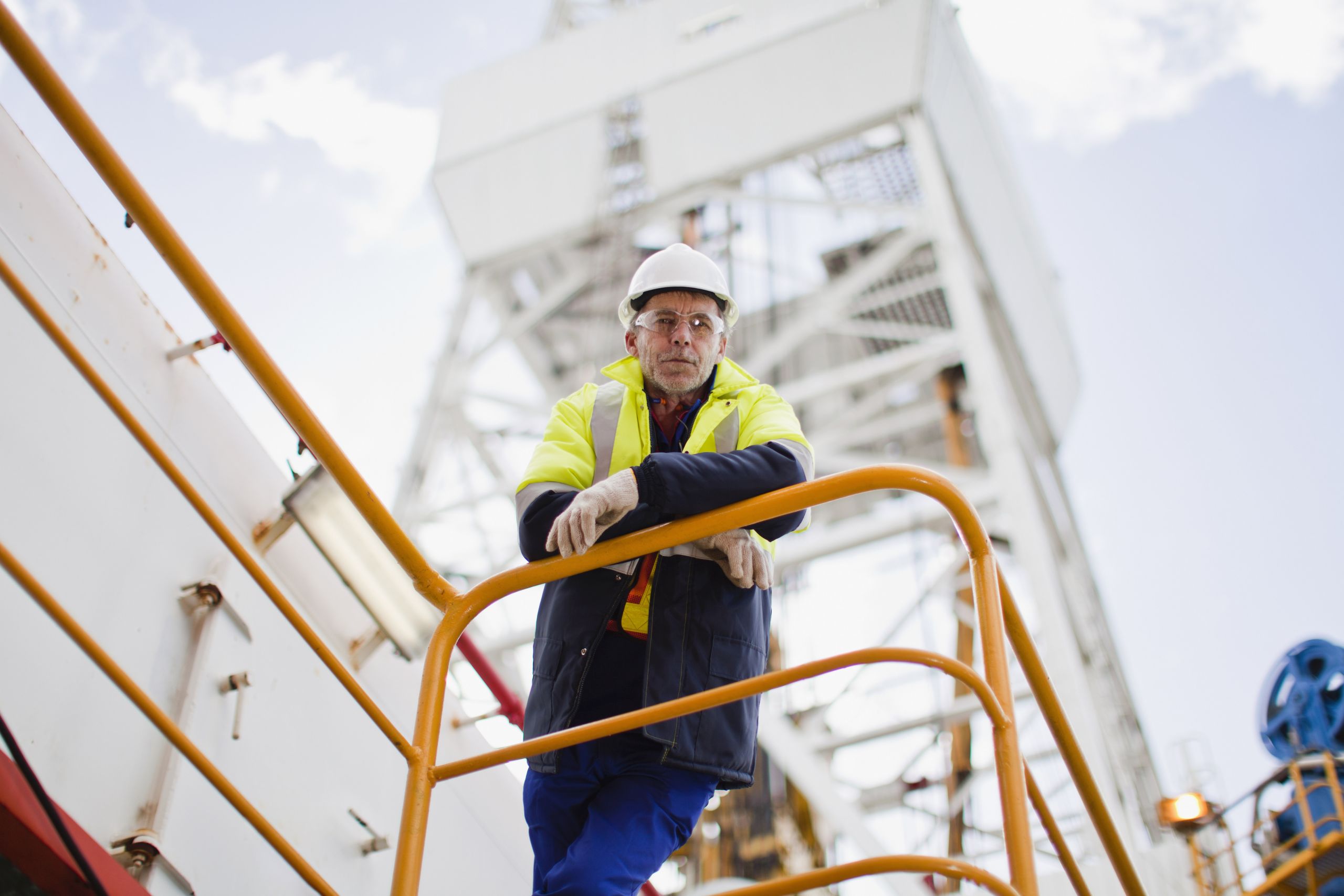 worker leaning on railling oil rig