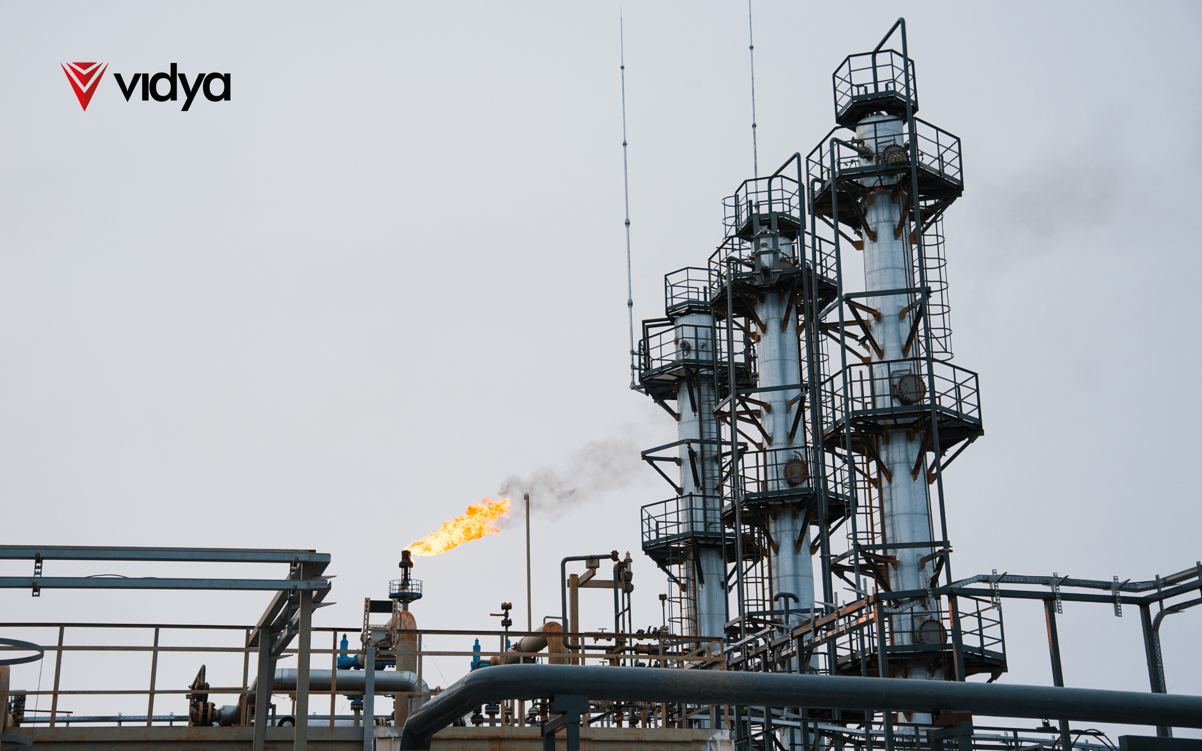 Industrial processing facility with flare stack and distillation columns, illustrating digital twin applications for asset integrity, inspection, and operational monitoring.