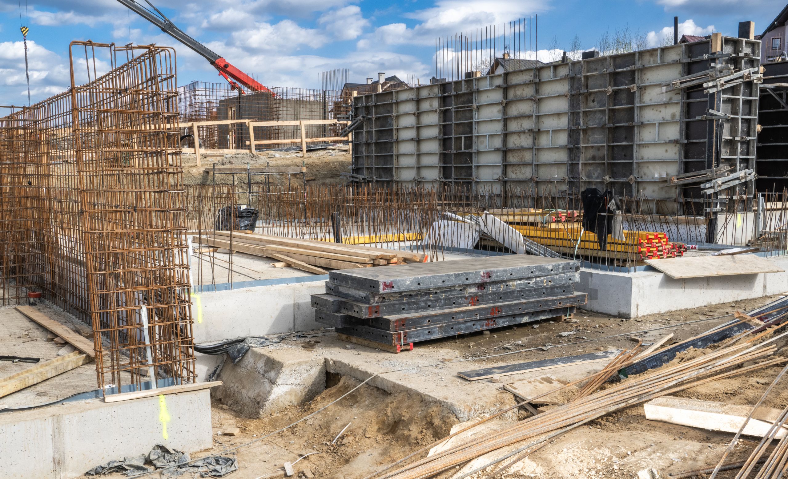 Construction Site With Foundation Work Underway in an Urban Area Surrounded by Machinery and Materials During a Clear Day Construction site