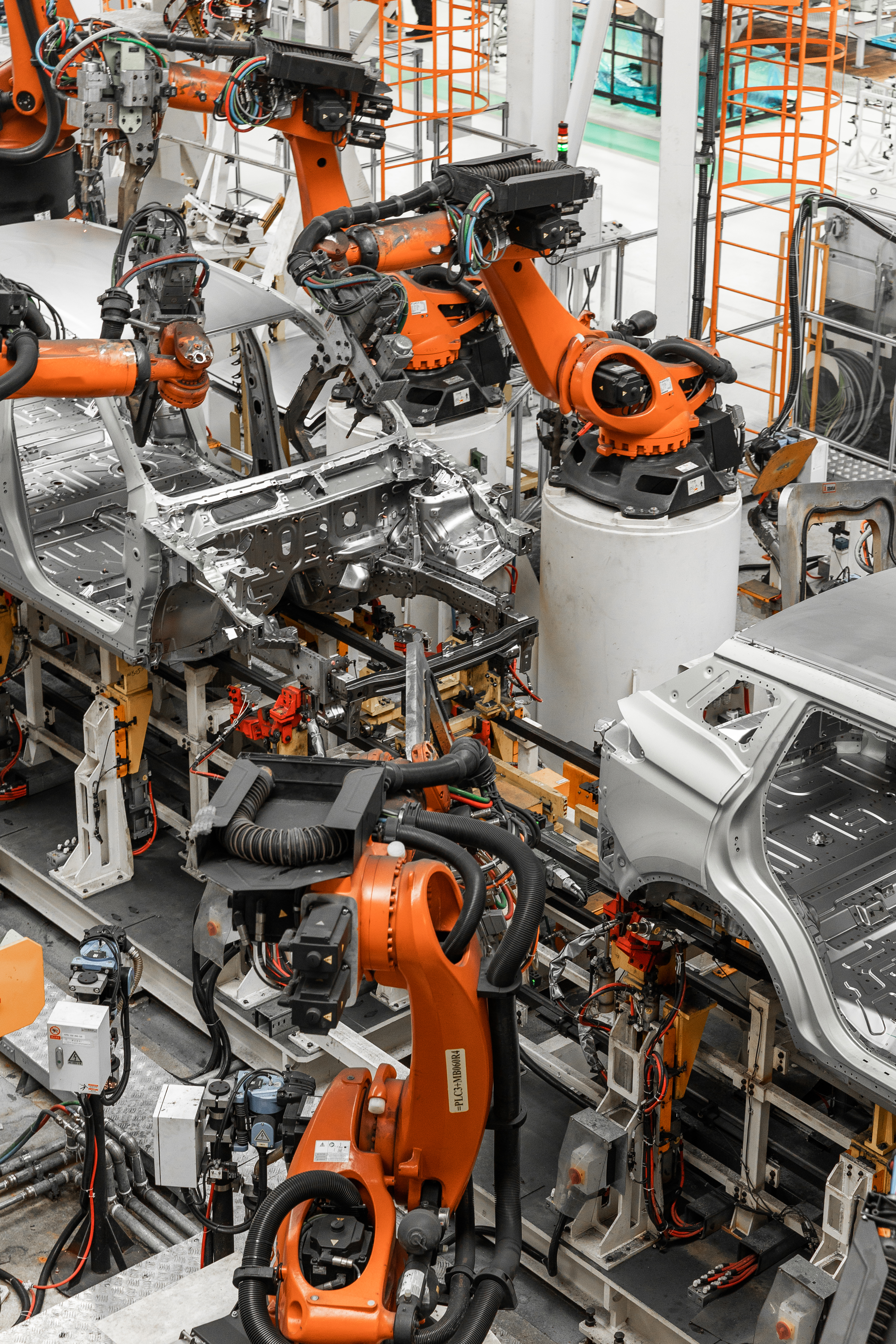 Vertical photo of automobile production line. Modern car assembly plant. Auto industry. Interior of a high-tech factory, modern production Car manufacturing line